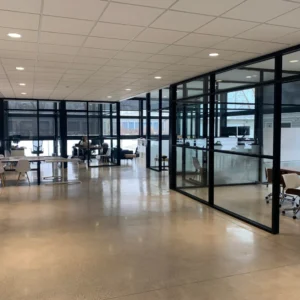 Oficina moderna con paredes de vidrio y escritorios